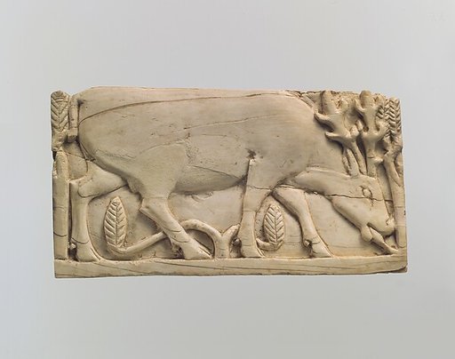 Furniture plaque carved in relief with a stag grazing among plants