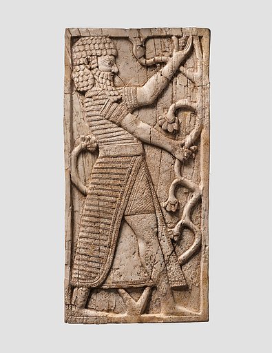 Furniture plaque carved in relief with striding man