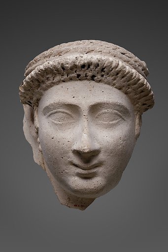Mask of a woman with an ornate curled bang and loop earrings