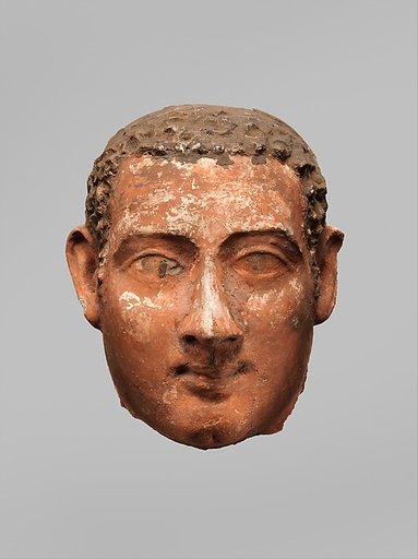 Mask of a man with short curly hair and long sideburns