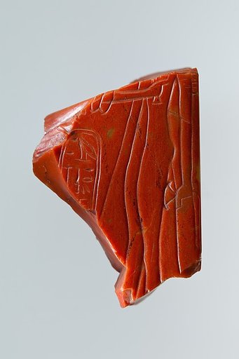 Statue fragment from a standing figure whose back pillar has cartouche of Ramesses II, and the figure of queen Nefertari incised on side