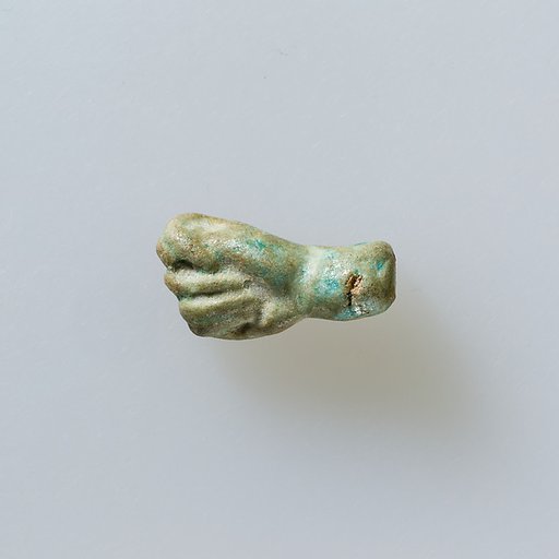 Amulet of fist with thumb thrust between first two fingers
