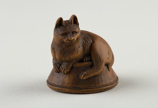 Netsuke of Cat Lying on a Bowl, underneath which is a Fish