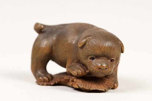 Netsuke of Puppy on Straw Mat Biting String