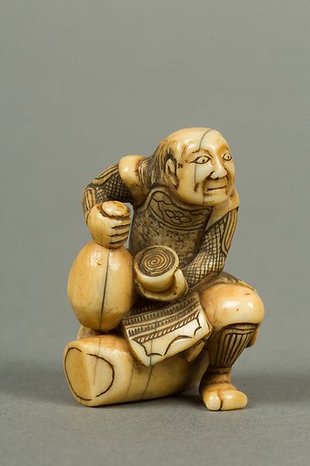 Netsuke of Man Sitting on a Log holding a Bottle and a Cup