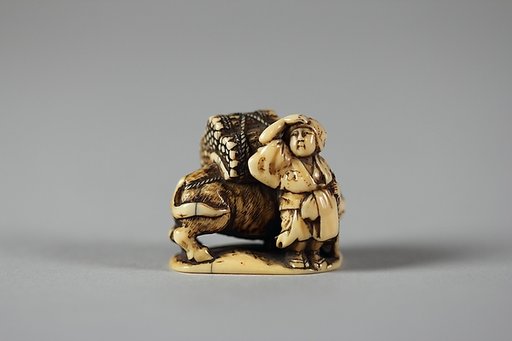 Netsuke of Man Leading an Ox with Bundles of Wood on its Back