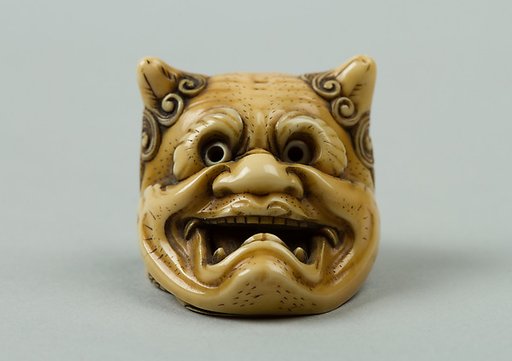 Netsuke of Okame under a Demon Mask