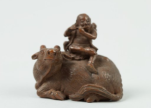 Netsuke of Man Playing Flute atop an Ox