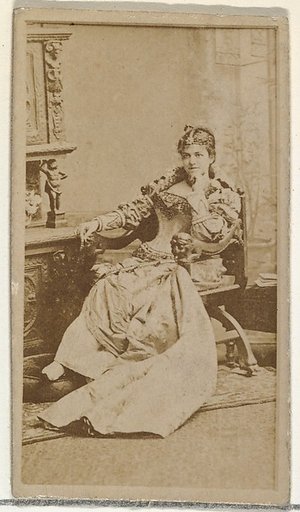 [Actress in studio reclining in heavy wooden chair], from the Actors and Actresses series (N145-8) issued by Duke Sons & Co. to promote Duke Cigarettes