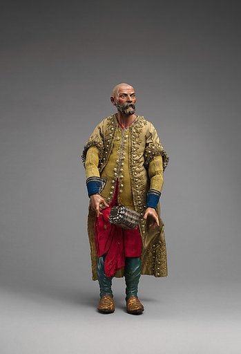 King in gold beaded coat, yellow vest, red pants with silver chest