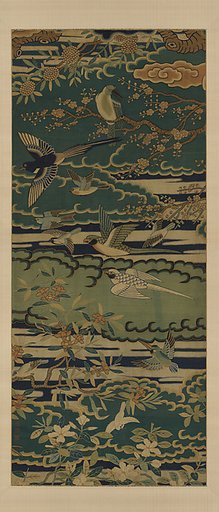 Birds among flowering branches against clouds