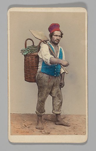 [Studio Portrait: Man Carrying Shovel and Basket of Greens]