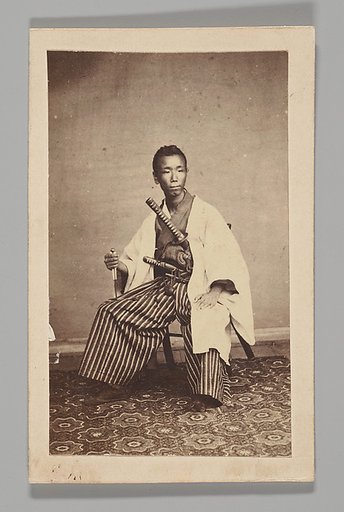 [Studio Portrait: Man Seated with Swords]