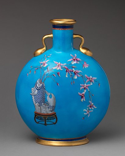 Moon flask with fish vase holding orchid spray