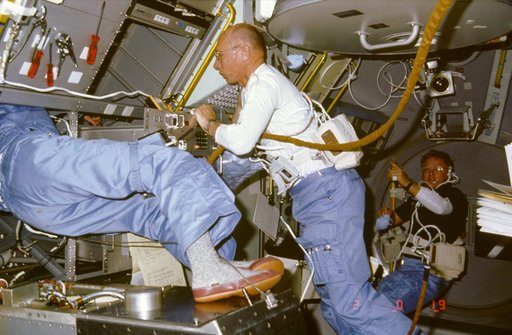 Astronaut William Thornton helps crewmember performs repairs on DDM