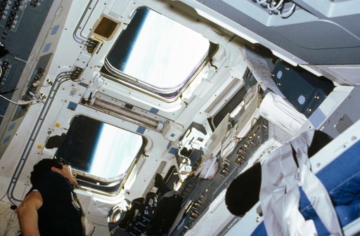 Payload specialist Lodewijk van den Berg looks out aft flight deck window