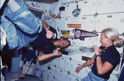 Astronauts Hoffman and Seddon demonstrate effect of weightlessness on slinky