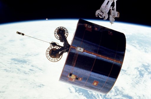 Astronaut James van Hoften working with Syncom IV-3 satellite