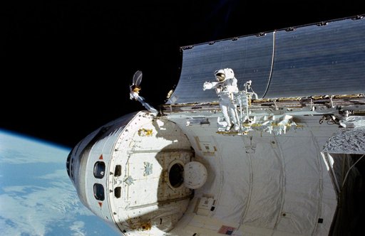 Astronaut William Fisher anchored to foot restraint on Discovery