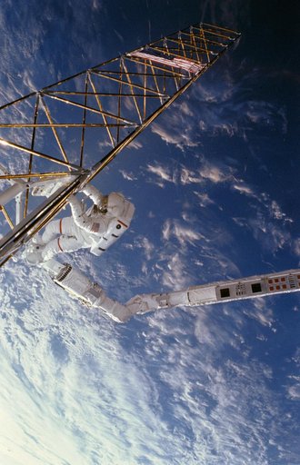 Astronaut Jerry Ross on RMS holds on to ACCESS device