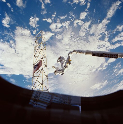 Astronauts Jerry Ross and Sherwood Spring survey assembled ACCESS components