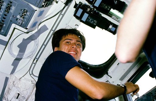 Astronaut Franklin Chang-Diaz checking payload bay through aft deck window