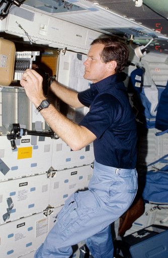 Rep. Bill Nelson prepares to photograph samples of protein crystal growth