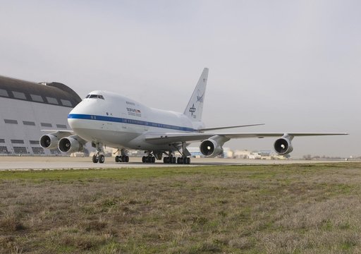 NASA's SOFIA airborne observatory taxis past Hangar 1, the 1930s-era dirigible hangar at Moffett Field, during its first visit to NASA Ames Research Center