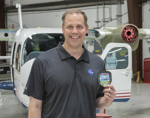 NASA Administrator Bridenstine receives X-57 all-electric aircraft program patch standing in front of the X-57 being modified at Scaled Composites at Mojave Air and Space Port in California.