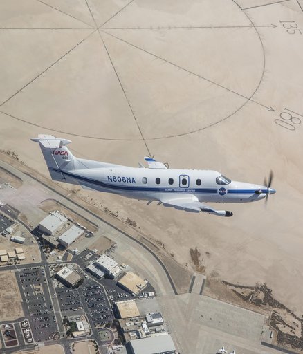 NASA Pilatus PC-12 cuts through the desert skies over NASA’s Armstrong Flight Research Center in Edwards, California with the compass rose in the background on Sept. 18, 2024.