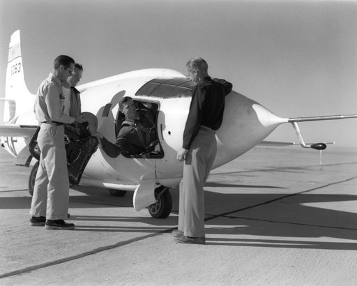NACA pilot John Griffith hands his flight gear to Dick Payne as crew members Ed Edwards and Clyde Bailey look on.
