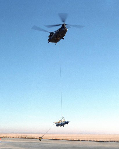 Ground crewmen help guide the alignment of the X-40A as the experimental craft is gently lowered to the ground by a U.S. Army CH-47 Chinook helicopter following a captive-carry test flight