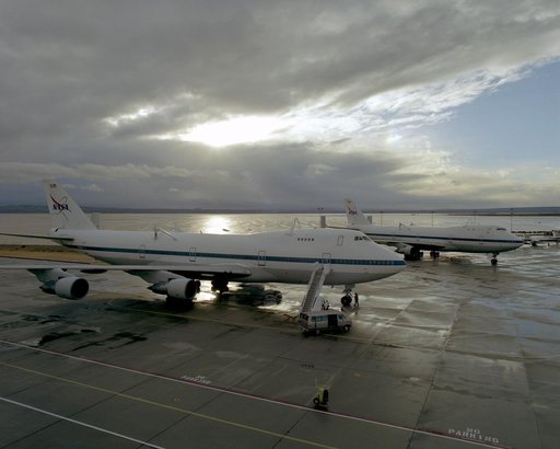The sun begins to break through the clouds over NASA's two 747 Shuttle Carrier Aircraft on the NASA Dryden ramp after a rain shower in February 2001