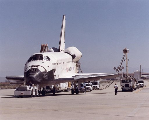 A convoy of specialized support vehicles follow the Space Shuttle Endeavour as it is towed up a taxiway at NASA's Dryden Flight Research Center on Edwards Air Force Base, California, after landing on May 1, 2001