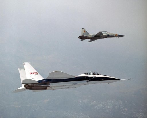 NASA's F-15B Research Testbed aircraft flies in the supersonic shock wave of a U.S. Navy F-5E as part of the F-5 Shaped Sonic Boom Demonstration (SSBD) project.