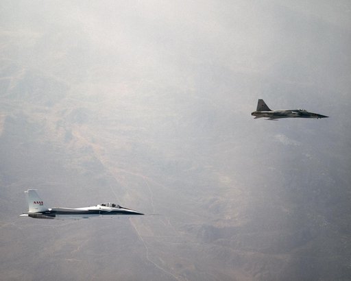 NASA's F-15B Research Testbed aircraft flies in the supersonic shock wave of a U.S. Navy F-5E as part of the F-5 Shaped Sonic Boom Demonstration (SSBD) project.