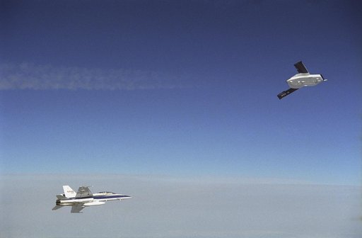 X-45A in flight with F-18 #846 chase aircraft, during first GPS-guided weapon demonstration flight