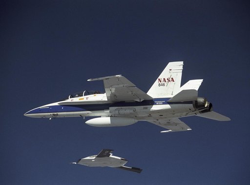 X-45A in flight with F-18 #846 chase aircraft, during first GPS-guided weapon demonstration flight