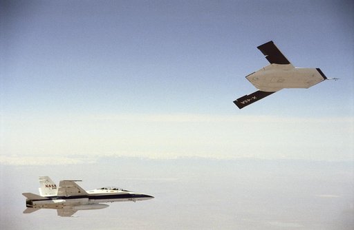X-45A in flight with F-18 #846 chase aircraft, during first GPS-guided weapon demonstration flight