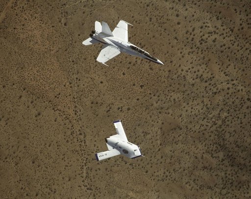 X-45A in flight with F-18 #846 chase aircraft, during first GPS-guided weapon demonstration flight