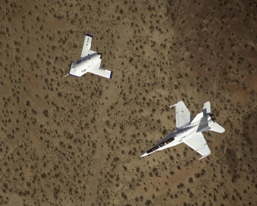 X-45A in flight with F-18 #846 chase aircraft, during first GPS-guided weapon demonstration flight