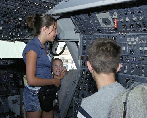 Leah Robson, Bridgette Puljiz and Zachary Johnson(back to camera) in the flight deck of NASA's 747 shuttle carrier during Take Your Children to Work Day