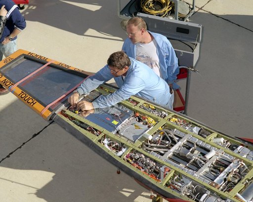 NASA avionics technicians Randy Wagner and Terry Bishop make final adjustments on the scramjet-powered X-43A before its record Mach 9.6 flight