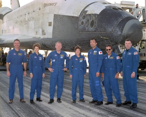 The crew of Space Shuttle mission STS-114 gathered in front of the shuttle Discovery following landing at Edwards Air Force Base, California, August 9, 2005