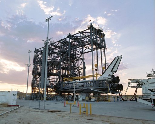 The sun sets on the Space Shuttle Discovery during post-flight processing in the Mate-Demate Device (MDD), following its landing at NASA DFRC in California