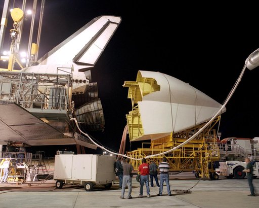 Workers position the tail cone on the Space Shuttle Discovery in preparation for its return to NASA's Kennedy Space Center in Florida