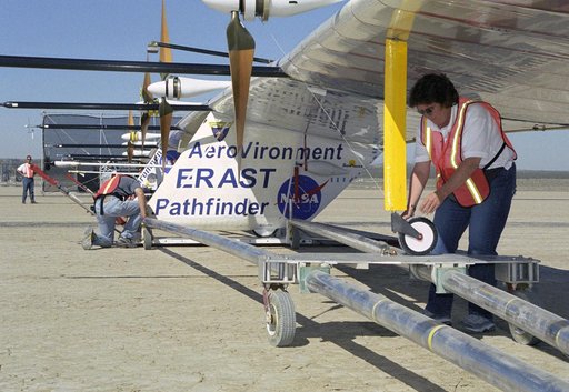 AeroVironment technicians prepare to remove the Pathfinder-Plus solar aircraft from its ground dolly before a turbulence measurement flight.