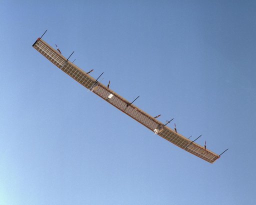 With sensor booms projecting ahead of the wing, the Pathfinder-Plus soars under a blue sky on its final turbulence measurement research flight.