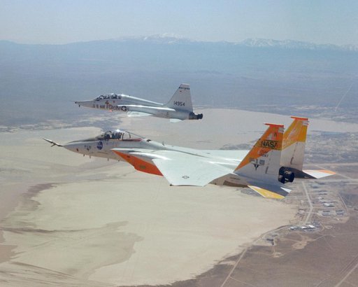 F-15A #287 flies formation with a T-38 chase over Edwards AFB.