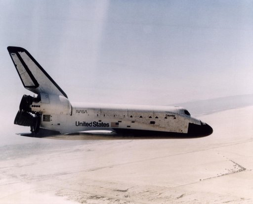 The Space Shuttle Columbia glides down over Rogers Dry Lake as it heads for a landing at Edwards Air Force Base at the conclusion of its first orbital mission